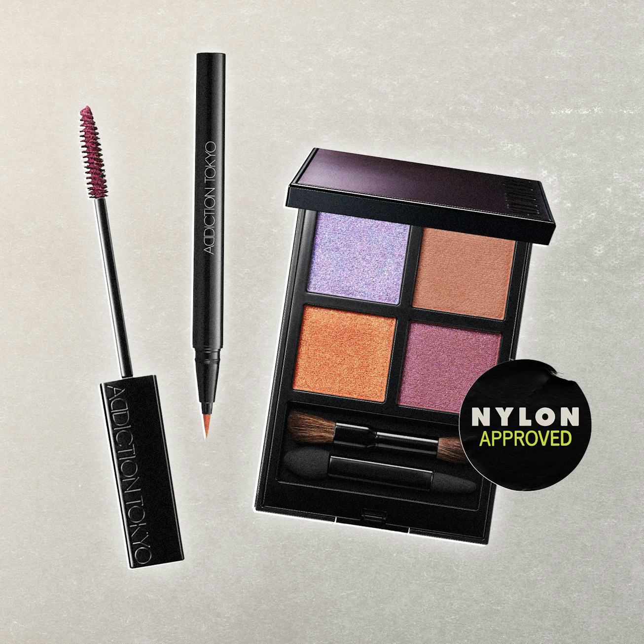 An array of makeup products is displayed, including a mascara, an eyeliner, and a four-color eyeshad...